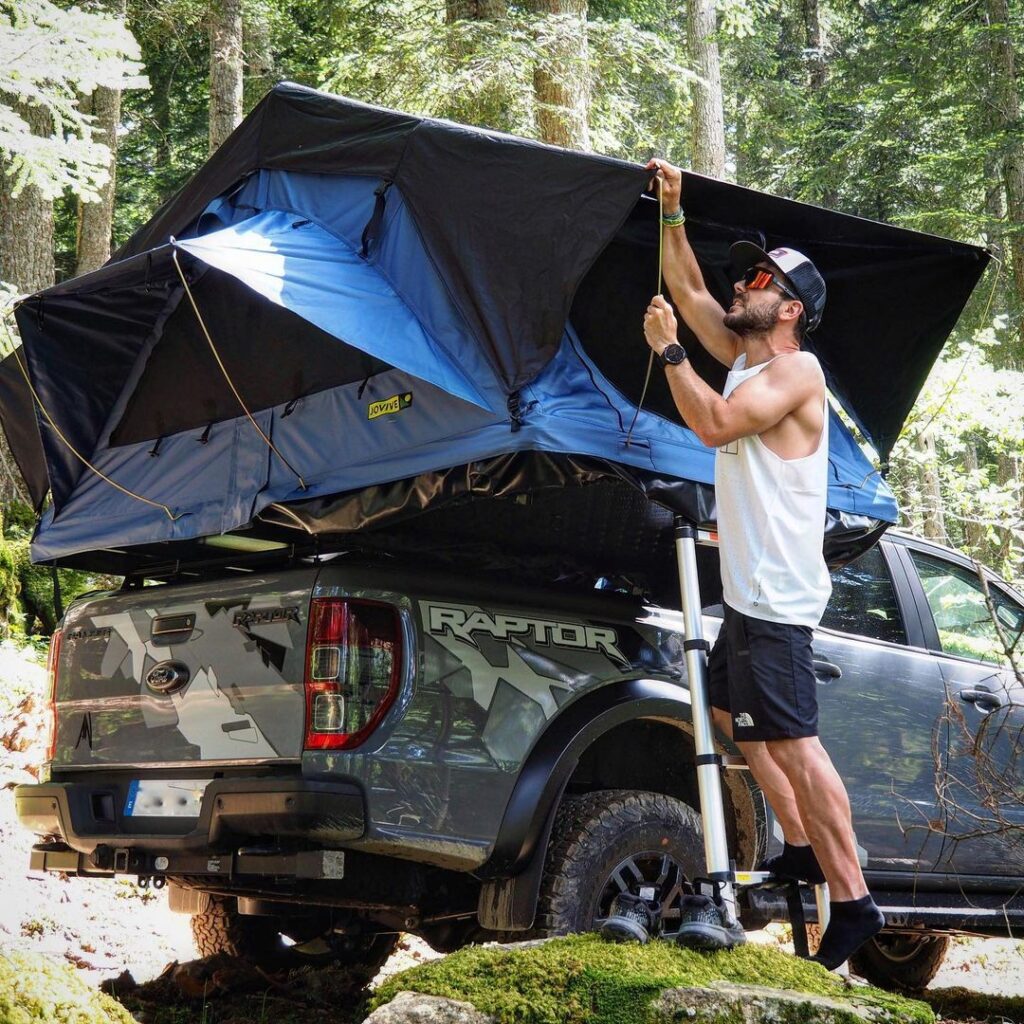 Photo d’un homme accrochant sa tente de toit à son véhicule. L’ouverture de sa tente de toit a pris moins de cinq minutes ! 